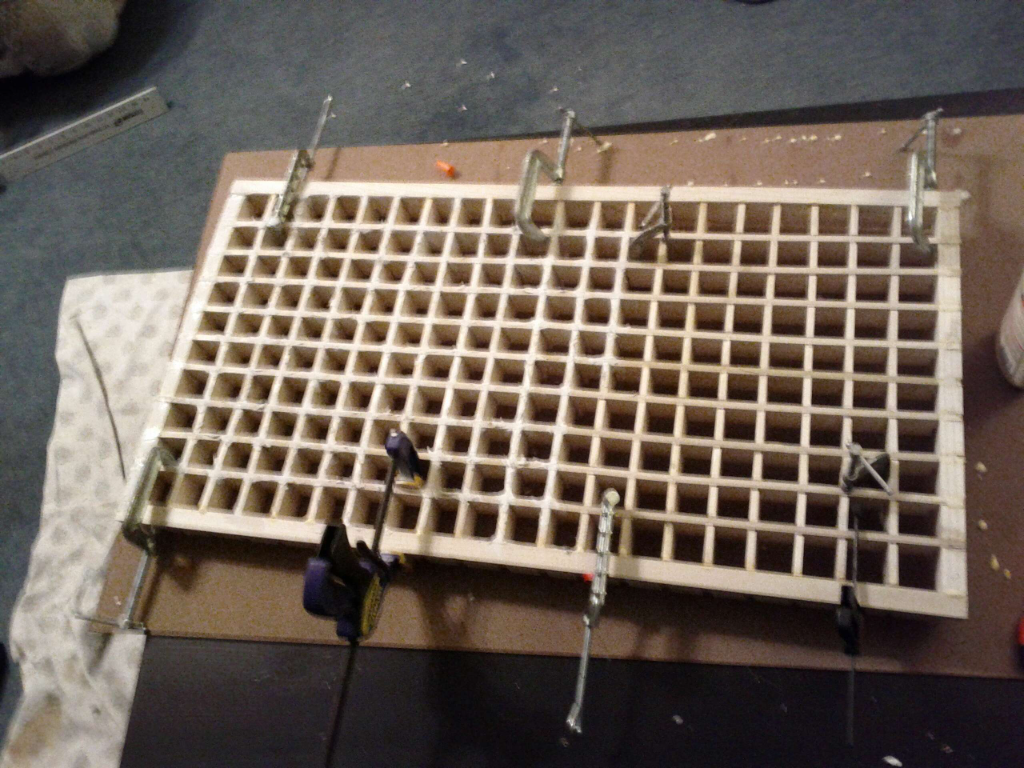 The wooden grid being secured during assembly